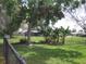 Lush, green backyard with a black chain-link fence, mature trees, and plenty of space at 11618 Grand Bay Blvd, Clermont, FL 34711