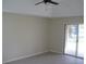 Bedroom with ceiling fan, neutral walls, light gray floors and sliding glass door to the backyard at 11618 Grand Bay Blvd, Clermont, FL 34711