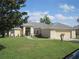 Charming single-story home boasts a well-manicured lawn, neutral paint, and an attached two-car garage at 11618 Grand Bay Blvd, Clermont, FL 34711
