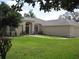 Beautiful single-story home with a lush green lawn, an arched entryway, and an attached garage at 11618 Grand Bay Blvd, Clermont, FL 34711