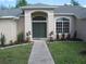 Beautiful entryway with double doors, arched transom window, and lovely landscaping at 11618 Grand Bay Blvd, Clermont, FL 34711