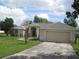 Well-maintained one-story home with a spacious driveway, attached garage, and attractive landscaping at 11618 Grand Bay Blvd, Clermont, FL 34711