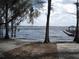 Picturesque lake view with a charming wooden dock and boat house, surrounded by trees and open water at 11618 Grand Bay Blvd, Clermont, FL 34711