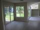 Bright living room with sliding glass doors and views of the landscaped backyard at 11618 Grand Bay Blvd, Clermont, FL 34711