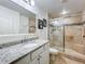 Bathroom featuring neutral stone shower and vanity with granite counters at 13407 Fountainbleau Dr # 5-2, Clermont, FL 34711