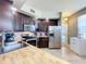 Kitchen featuring stainless steel appliances, dark wood cabinetry and a light wood countertop island at 13407 Fountainbleau Dr # 5-2, Clermont, FL 34711