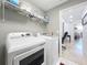 Laundry room with washer, dryer, wire shelving, and a view into an office area at 13407 Fountainbleau Dr # 5-2, Clermont, FL 34711