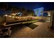 Night view of backyard with bocce ball court, string lights, and a view of a high rise building at 135 Dundee Rd, Daytona Beach, FL 32118