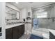 Modern bathroom featuring a shower and bathtub, updated lighting, wood vanity, and elegant mirror at 135 Dundee Rd, Daytona Beach, FL 32118