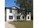 Two story home featuring white siding, black trim, new windows, a large tree and a concrete driveway at 15 E Laurel St, Apopka, FL 32703