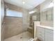 This bathroom boasts a step-in shower with light tile and a single vanity with marble countertop at 164 Morning Glory Dr, Lake Mary, FL 32746