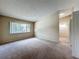 A neutral-toned bedroom features carpet, a large window, and access to other rooms in the house at 164 Morning Glory Dr, Lake Mary, FL 32746