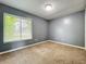 This empty bedroom features neutral walls, carpeted flooring, and a bright window with lush, green scenery at 164 Morning Glory Dr, Lake Mary, FL 32746