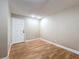 This is a simple, empty room with hardwood floors and a white door to enter or exit at 164 Morning Glory Dr, Lake Mary, FL 32746