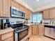 Galley kitchen featuring stainless steel appliances and granite countertops at 164 Morning Glory Dr, Lake Mary, FL 32746