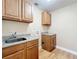 A laundry room featuring wooden cabinets and sink with connections for a washing machine at 164 Morning Glory Dr, Lake Mary, FL 32746
