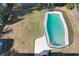 An aerial view of a home's backyard featuring a turquoise blue pool with patio and fence at 164 Morning Glory Dr, Lake Mary, FL 32746