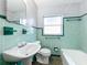 Retro bathroom with green tile, pedestal sink, and tub at 1930 Albert Lee Pkwy, Winter Park, FL 32789