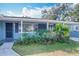 Light blue house with a covered porch, dark blue door, and lush landscaping at 1930 Albert Lee Pkwy, Winter Park, FL 32789