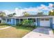 Light blue house with a white garage door and palm trees at 1930 Albert Lee Pkwy, Winter Park, FL 32789