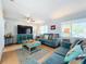 Living room with teal sofas, wood coffee table, and large TV at 1930 Albert Lee Pkwy, Winter Park, FL 32789