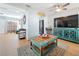 Living area with teal cabinet, wood floors, and comfy seating at 1930 Albert Lee Pkwy, Winter Park, FL 32789