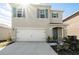 Two-story house with a white garage door and green shutters at 2630 Angel Falls Dr, Davenport, FL 33837