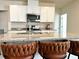 Stylish kitchen island with granite countertops, white cabinets, and leather counter seating at 2630 Angel Falls Dr, Davenport, FL 33837