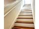 Staircase with white risers and stained wood treads plus a white handrail in a home interior at 2630 Angel Falls Dr, Davenport, FL 33837
