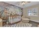 Charming Bedroom with whimsical mural, comfortable seating, and a crib, creating a warm and inviting space at 3010 Bay Tree Dr, Orlando, FL 32806