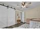 Bright Bedroom featuring modern farmhouse-style decor, including white barn doors and a cozy crib at 3010 Bay Tree Dr, Orlando, FL 32806