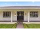 Close-up of a home's front entrance featuring a decorative glass door, black window trim and a brick walkway at 3010 Bay Tree Dr, Orlando, FL 32806