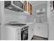 Updated kitchen featuring stainless steel gas range, range hood, white cabinets, and stone countertops at 3010 Bay Tree Dr, Orlando, FL 32806