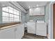 Well-lit laundry room with front loading washer and dryer, sink, and ample cabinet space at 3010 Bay Tree Dr, Orlando, FL 32806
