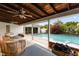Inviting covered patio with wicker seating overlooks a sparkling pool and lush, tropical backyard oasis at 3010 Bay Tree Dr, Orlando, FL 32806