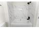 Bathroom with a tub and shower featuring marble-like tiled walls at 3013 Bonfire Beach Dr # 101, Kissimmee, FL 34746