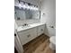 Updated bathroom with quartz countertops, new vanity, black fixtures, and wood-look tile flooring at 3013 Bonfire Beach Dr # 101, Kissimmee, FL 34746