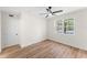 Bright, minimalist bedroom with hardwood floors, a large window, and a ceiling fan at 3013 Bonfire Beach Dr # 101, Kissimmee, FL 34746