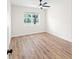 Minimalist bedroom with hardwood floors, a ceiling fan, and a large window at 3013 Bonfire Beach Dr # 101, Kissimmee, FL 34746