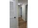 Hallway featuring laminate floors, white trim, and doors, with a flush mount ceiling light at 3013 Bonfire Beach Dr # 101, Kissimmee, FL 34746