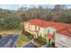 Three-unit townhome building with orange tile roofs and a shared parking lot at 346 Monroe Cir, Davenport, FL 33896