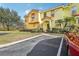 Two-story townhome with orange and yellow exterior, landscaped lawn, and parking at 346 Monroe Cir, Davenport, FL 33896