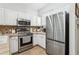 Modern kitchen with stainless steel appliances and white cabinets at 346 Monroe Cir, Davenport, FL 33896