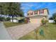 Two-story house with red accents and a brick driveway at 3720 Ryegrass St, Clermont, FL 34714