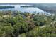 Stunning aerial view of lakefront property with lush greenery and a private dock along the serene waterfront at 4135 Chuluota Rd, Orlando, FL 32820