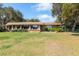Brick ranch house with large windows and a spacious lawn at 4135 Chuluota Rd, Orlando, FL 32820