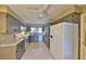 Galley-style kitchen with gray cabinets, white appliances, and marble countertops at 4135 Chuluota Rd, Orlando, FL 32820