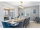 Modern dining room with a long white table and blue chairs at 4152 Paragraph Dr, Kissimmee, FL 34746