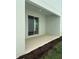 Covered patio area perfect for outdoor relaxing, complete with sliding glass doors and tidy landscaping at 520 Orient Ave, Debary, FL 32713