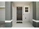 Modern front door with a welcome mat and gray columns at 5427 Dragonfly Dr, Wildwood, FL 34785